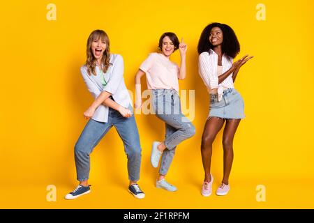 Photo pleine grandeur de Nice optimiste trois vêtements de danse pour femmes jean blanc avec chemise isolée sur fond jaune vif Banque D'Images