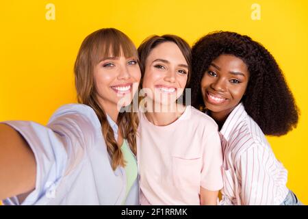 Photo de Nice optimiste trois dames ne selfie porter blanc chemise isolée sur fond jaune vif Banque D'Images