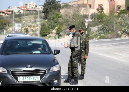 9 mars 2021 : Tulkarem, Cisjordanie, Palestine. 09 mars 2021. Des membres des forces de sécurité nationales palestiniennes vérifient les véhicules qui se déplacent dans la ville de Tulkarem, alors qu'un nouveau confinement est imposé en Cisjordanie pour contenir une nouvelle vague de cas de Covid-19. Malgré un couvre-feu nocturne en place depuis une semaine, il y a eu une forte augmentation des cas de coronavirus chez les Palestiniens en Cisjordanie. Les restrictions en vertu du confinement actuel comprennent la fermeture d'écoles, d'universités et d'entreprises non essentielles crédit: Mohammed Turabi/IMAGESLIVE/ZUMA Wire/Alay Live News Banque D'Images