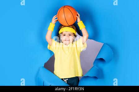 Petit ballon de base. Un enfant dans un vêtement de sport jette le ballon. Entraînement au basket-ball. Équipements sportifs. Activités sportives pour enfants. Banque D'Images