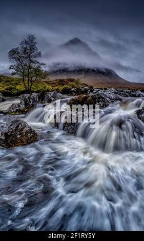 Cascade spectaculaire à Glencoe en Écosse. Glen Etive dans les Highlands écossais photographié lors d'une journée de tempête avec de lourds nuages bas Ecosse Royaume-Uni Banque D'Images