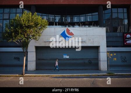 Mar del Plata, Buenos Aires, Argentine - Mai, 2020: Femme dans le masque de protection promenades près du centre commercial Los Gallegos fermé pendant le confinement Banque D'Images