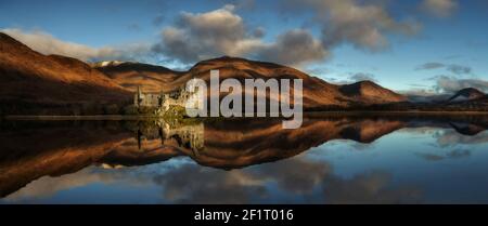 Ruines du château de Kilchurn surplombant le Loch Awe dans les Highlands écossais, avec des montagnes accidentées créant un paysage historique dramatique. Banque D'Images
