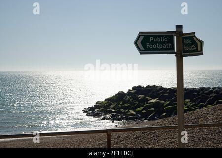 Panneau de sentier public le long d'une plage dans le sud de l'Angleterre. Mer, plage, horizon et rochers en arrière-plan. Banque D'Images