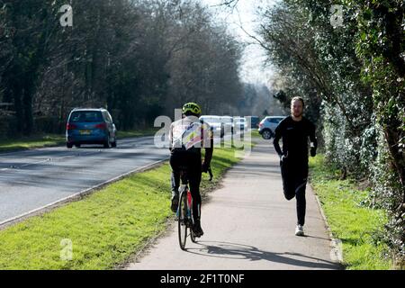 Cycliste et coureur sur un double sentier de cyclisme/marche pendant le verrouillage Covid-19, Warwick, Royaume-Uni. Mars 2021. Banque D'Images