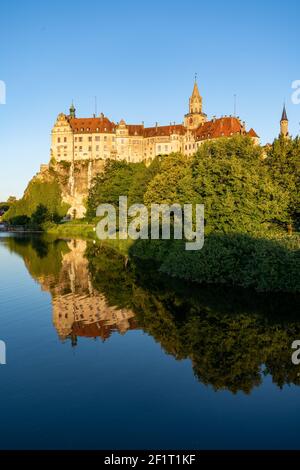 Vue sur le château de Hohenzollern Sigmaringen au coucher du soleil avec réflexions Dans le Danube Banque D'Images