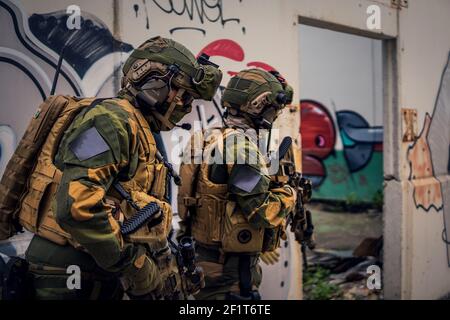 Des soldats des forces spéciales entièrement équipés en action, une opération dans un bâtiment délabré Banque D'Images