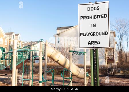 Chiens interdits dans la zone de jeu Inscrivez-vous devant les clôtures d'un terrain de jeu clôturé d'un quartier résidentiel de banlieue. Les animaux de compagnie peuvent causer des problèmes de ville Banque D'Images
