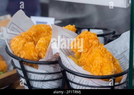 Poisson frit ou poulet dans de la pâte emballée dans le journal à marché alimentaire - gros plan Banque D'Images