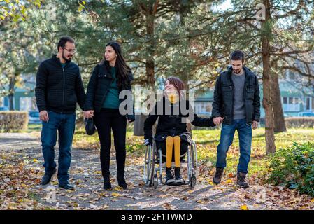Jeune femme handicapée avec des amis dans un parc Banque D'Images