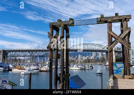 Embarcadère des ferries de Granville Island. Le pont de la rue Burrard et les édifices de Vancouver s'offrent à eux en arrière-plan. Banque D'Images