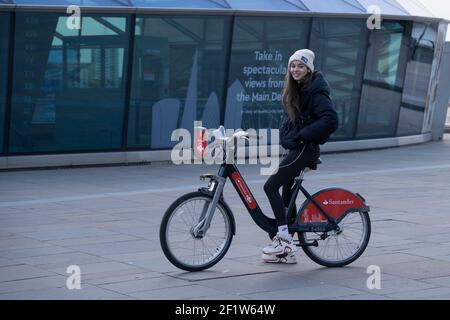 Une jeune femme sourit sur ses arrêts de vélo Santander loués et vérifie son itinéraire autour de cutty sark pendant sa tournée de Londres Greenwich Banque D'Images