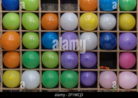 Ballons gonflables multicolores dans les cellules pour jouer aux fléchettes, gros plan. Banque D'Images