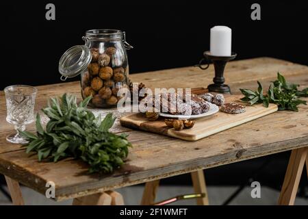 Une composition rustique avec un pot de noix, de bonbons et un décor sur une table en bois Banque D'Images