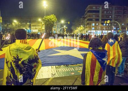 Les manifestants sont couverts de drapeaux d'indépendance catalanes et ils tiennent des fusées devant un drapeau d'indépendance géant.les groupes d'indépendance catalanes célèbrent les 365 jours de coupures de l'avenue Meridiana, à Barcelone, où ils rassemblent quotidiennement des prisonniers politiques catalans pour des manifestations de liberté et pour l'indépendance de la Catalogne. À cette occasion, ils ont également exprimé les résultats du vote sur la demande du Parlement européen qui a approuvé ce mardi le retrait de l'immunité parlementaire de l'ancien président de la Catalogne Carles Puigdemont et de l'ancien conseiller Toni C. Banque D'Images