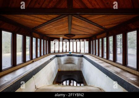 Une piscine intérieure remplie d'eau sale à l'intérieur d'un manoir abandonné. Banque D'Images