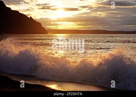 Surf en mer à Glerhallavik au coucher du soleil, Islande, Europe Banque D'Images