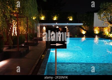 Panneau des toilettes devant la piscine publique la nuit Banque D'Images