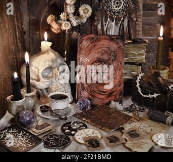 La vie encore effrayante avec des bougies en feu, crâne, livre de grimoire et cartes de tarot sur table de sorcière. Arrière-plan ésotérique, gothique et occulte, Halloween mystic c Banque D'Images