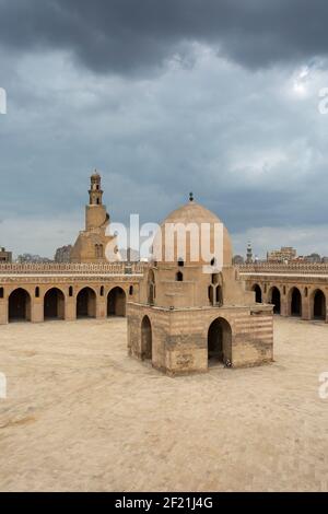 La mosquée d'Ibn Tulun montrant la fontaine d'ablution, la cour et le minaret sous les nuages sombres de la tempête, à Tolon, El-Sayeda Zainab, le Caire, Egypte Banque D'Images