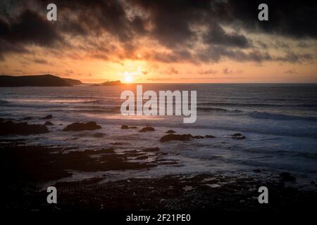 Un coucher de soleil intense sur la baie de Fistral à Newquay, sur la côte nord de Cornwall. Banque D'Images