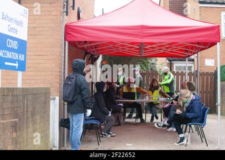 Londres, Royaume-Uni, 10 mars 2021 : les gens attendent leur vaccination à l'extérieur d'un centre du NHS à Balham, dans le sud de Londres. Les volontaires ont joué un rôle crucial dans l'assistance au personnel du NHS dans le déploiement très réussi des vaccins, qui a donné à près de 23 millions de personnes leurs premiers injections -- plus d'un tiers de la population. Anna Watson/Alay Live News Banque D'Images