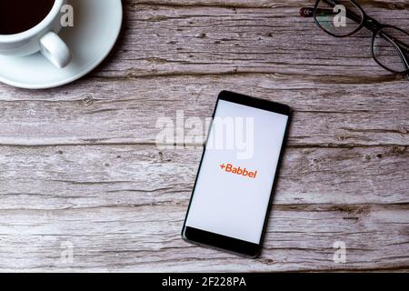 Un téléphone portable ou mobile posé sur un bois Table ou bureau avec l'application de langue Babbel ouverte Banque D'Images