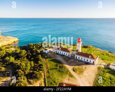 Côte de Cliffy en Algarve avec le phare d'Alfazinha à Carvoeiro, Portugal Banque D'Images