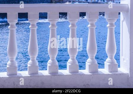 Vue à travers une balustrade blanche sur la mer, glising au soleil Banque D'Images