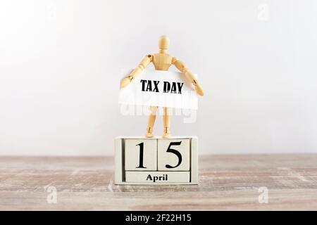 Le modèle homme en bois est inscrit sur un calendrier du 15 avril et tient une inscription jour de l'impôt. Date limite DE paiement DES taxes AUX ÉTATS-UNIS. Banque D'Images