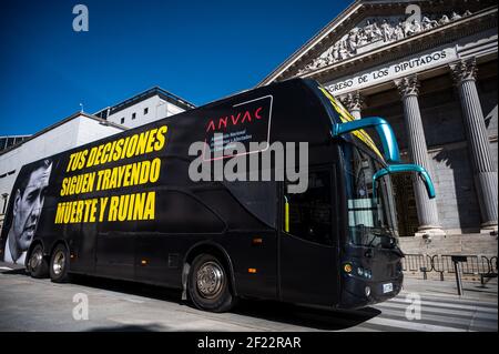 Madrid, Espagne. 10 mars 2021. Un bus de l'Association nationale des victimes et affectées par le coronavirus (ANVAC), avec la photo du Président de l'Espagne, Pedro Sanchez et les mots "vos décisions continuent d'apporter la mort et la ruine" passe par le Congrès des députés. Credit: Marcos del Mazo/Alay Live News Banque D'Images