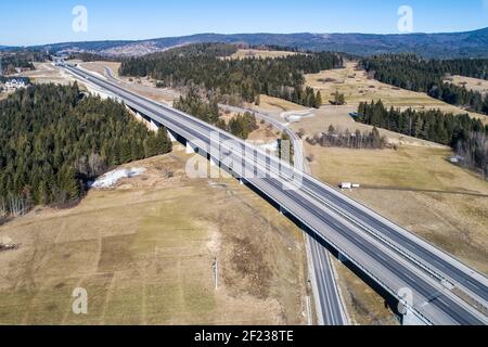 Ancienne route et nouvelle autoroute de Cracovie à Zakopane en Pologne, appelée Zakopianka avec viaducs, carrefour élevé et voitures. Vue aérienne en hiver Banque D'Images