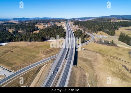 Ancienne route et nouvelle autoroute de Cracovie à Zakopane en Pologne, appelée Zakopianka avec viaducs, carrefour élevé et voitures. Vue aérienne en hiver Banque D'Images