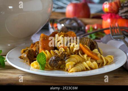 Ragoût de citrouille avec du bœuf et des pâtes servi sur une assiette sur la table de ktichen Banque D'Images