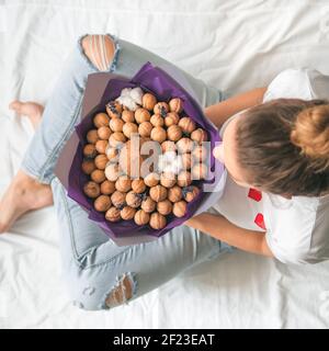 Jeune femme avec noix de coco manger bouquet Banque D'Images