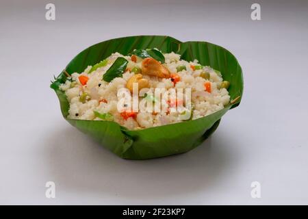 Upma fait de samolina ou de rava, le petit-déjeuner indien du sud qui est magnifiquement arrangé dans un bol en feuille de banane et garni de noix de cajou frites Banque D'Images