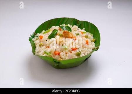 Upma fait de samolina ou de rava, le petit-déjeuner indien du sud qui est magnifiquement arrangé dans un bol en feuille de banane et garni de noix de cajou frites Banque D'Images