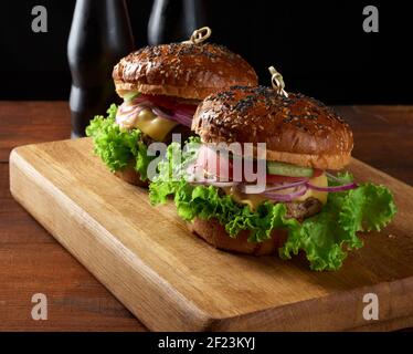 Hamburger avec côtelettes de bœuf frites et oignons, pain croustillant à la farine de blé blanc avec graines de sésame Banque D'Images