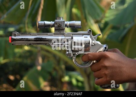 Pistolet à jouets en plastique isolé sur fond naturel Banque D'Images