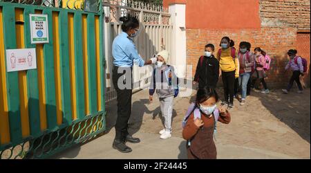 Katmandou, Bagmati, Népal. 10 mars 2021. Les élèves népalais avec leur masque prennent un thermomètre à vérifier lorsqu'ils entrent à la porte d'entrée de l'école dans la zone des tout-petits de Nawaneet à Katmandou, au Népal, le 10 mars 2021. Crédit : Sunil Sharma/ZUMA Wire/Alay Live News Banque D'Images