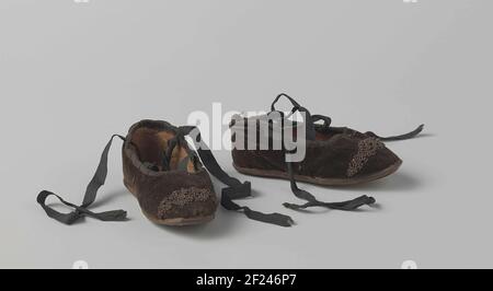 Schoen van zwart fluweel.Black Velvet Shoe. Gauche et droit égal, crucificateurs, semelle en cuir, ornée de perles de métal (rouillées). Peut-être une chaussure pour enfants ou une chaussure de poupées. Banque D'Images