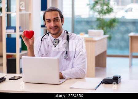 Jeune homme médecin cardiologue travaillant dans la clinique Banque D'Images