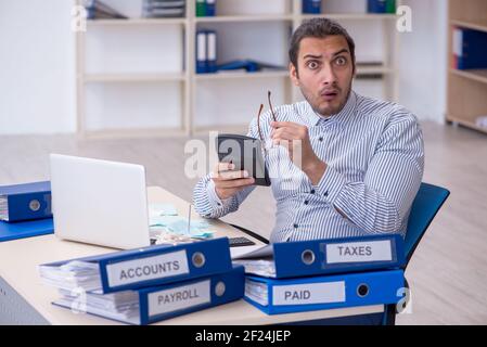 Jeune homme comptable calculant les paiements d'impôt au bureau Banque D'Images