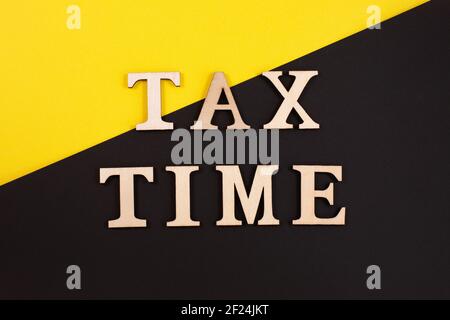 Le modèle homme en bois est inscrit sur un calendrier du 15 avril et tient une inscription jour de l'impôt. Date limite de paiement des taxes. Banque D'Images