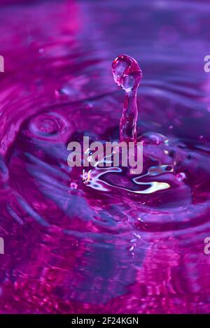 Gouttes d'eau et ondulations sur un arrière-plan coloré. Texture d'arrière-plan d'eau naturelle incroyable. Banque D'Images