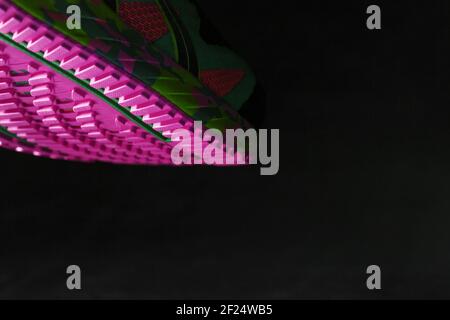 Semelle rose texturée des chaussures de course à pied sur fond noir. Des couleurs modernes et originales. Style sportif, gros plan Banque D'Images