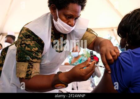 (210310) -- KAMPALA, le 10 mars 2021 (Xinhua) -- UN agent de santé administre une injection de vaccin COVID-19 à une femme lors du lancement de la campagne de vaccination à l'hôpital spécialisé pour femmes et nouveau-nés de Mulago à Kampala, en Ouganda, le 10 mars 2021. L'Ouganda a lancé mercredi la première phase de la campagne de vaccination COVID-19 visant les groupes à haut risque dans le pays d'Afrique de l'est. (Photo de Hajarah Nalwadda/Xinhua) Banque D'Images