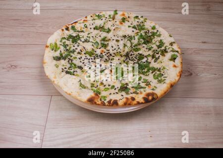 pain plat spécial indien également connu sous le nom de kulcha tandoori ou naan, servi dans une assiette blanche en céramique Banque D'Images