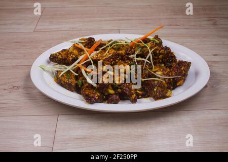 Paneer Chilis est un plat indien, paneer cubes avec tomates, oignons, ciboules, sauce Chili. Servi sur un fond de bois rustique, focu sélectif Banque D'Images