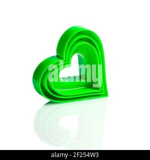 Moule en plastique de couleur verte pour couper les biscuits cardiaques sur fond blanc, différentes tailles. Produits de la Saint-Valentin. Lot de trois. Isoler. Banque D'Images